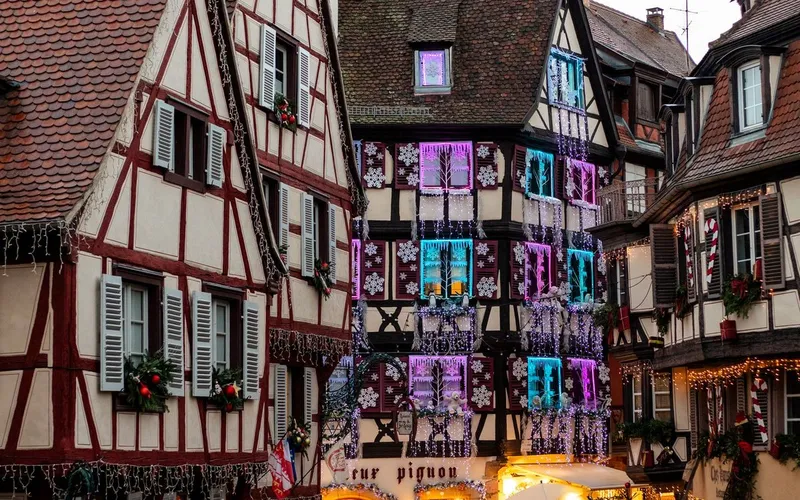 Maisons à colombages de Colmar décorées de lumières et de flocons, à la tombée du jour
